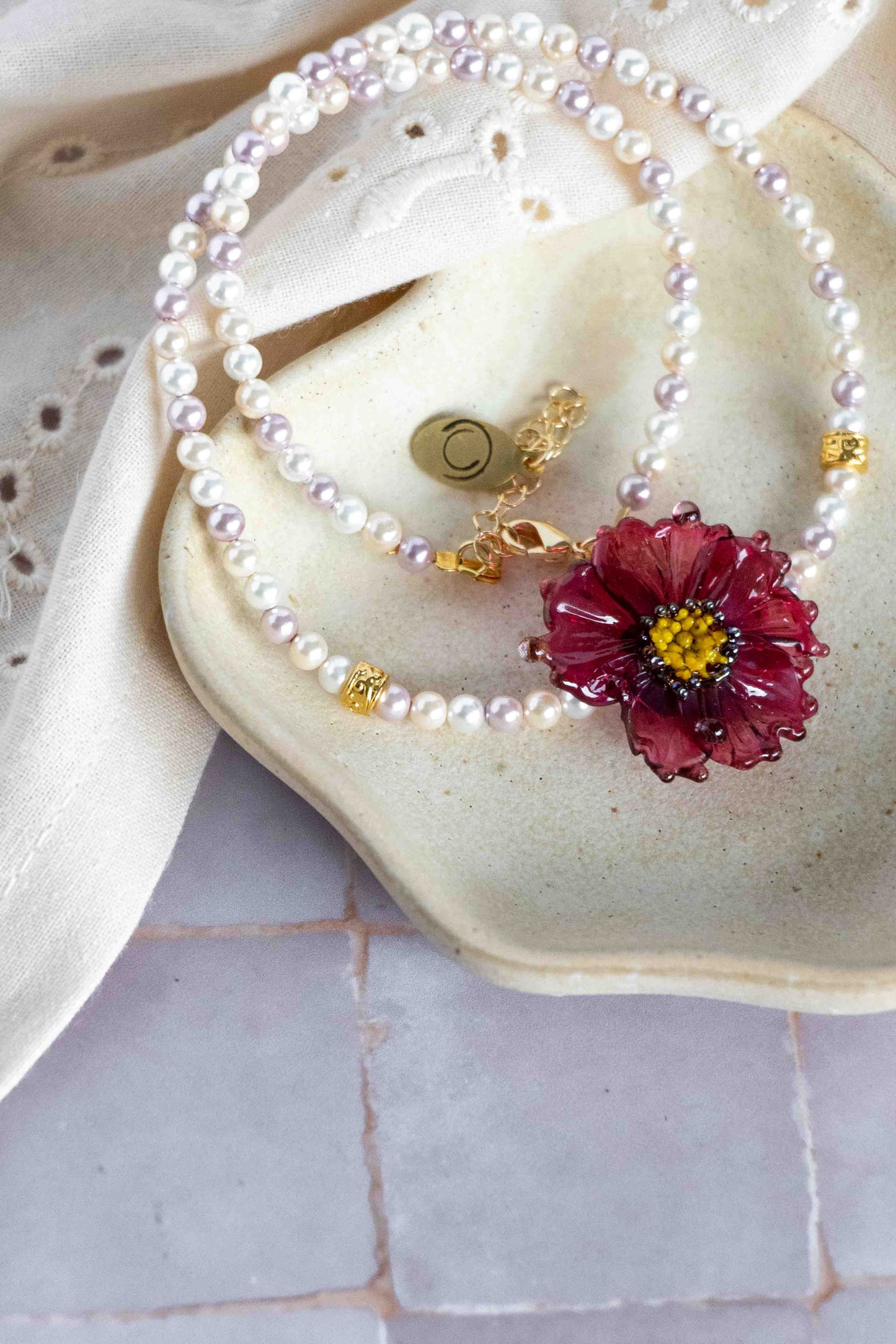 Pearl necklace with a floral pendant on a minimal setting