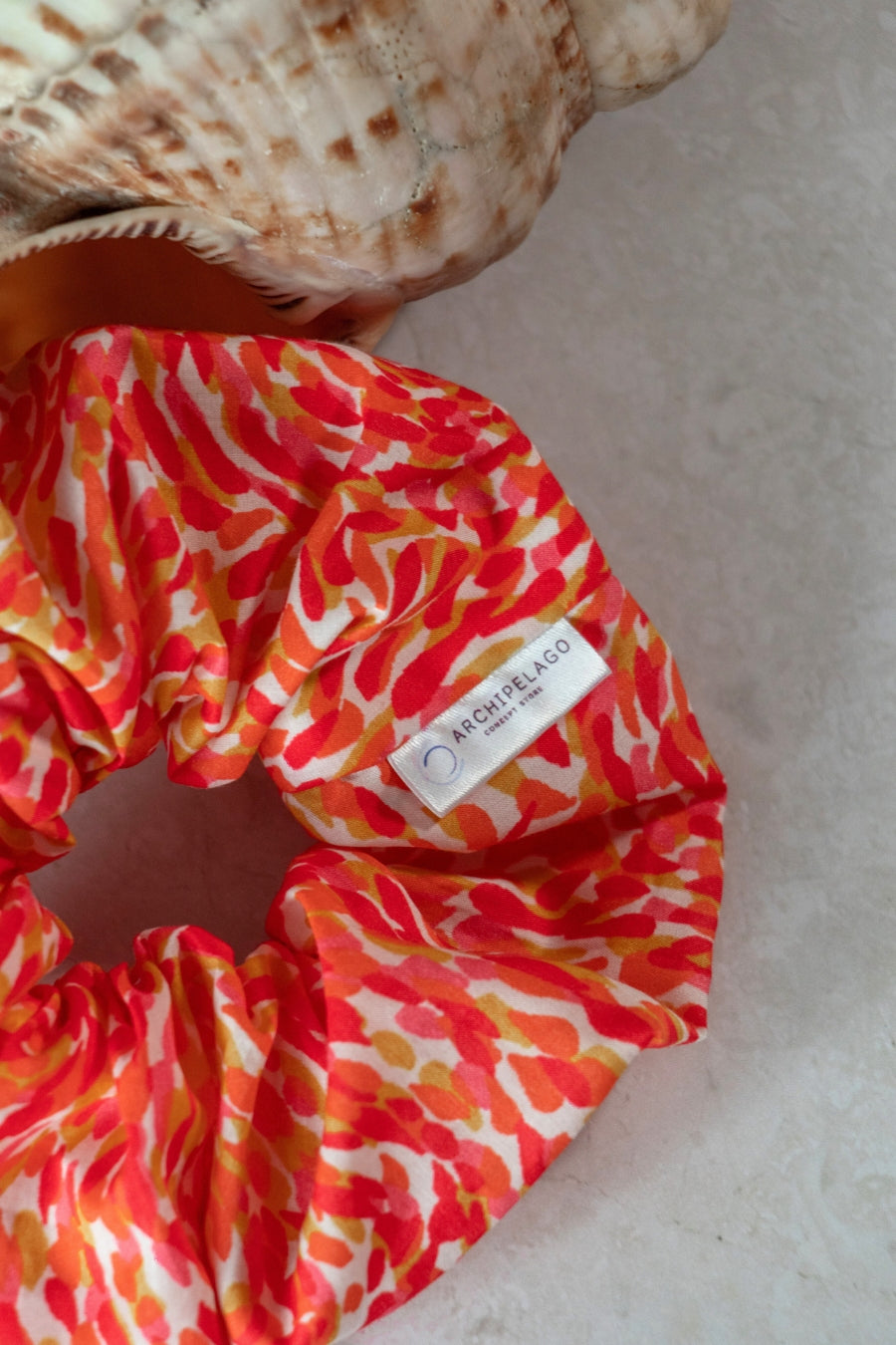 Colorful scrunchie with a brand label on a light background