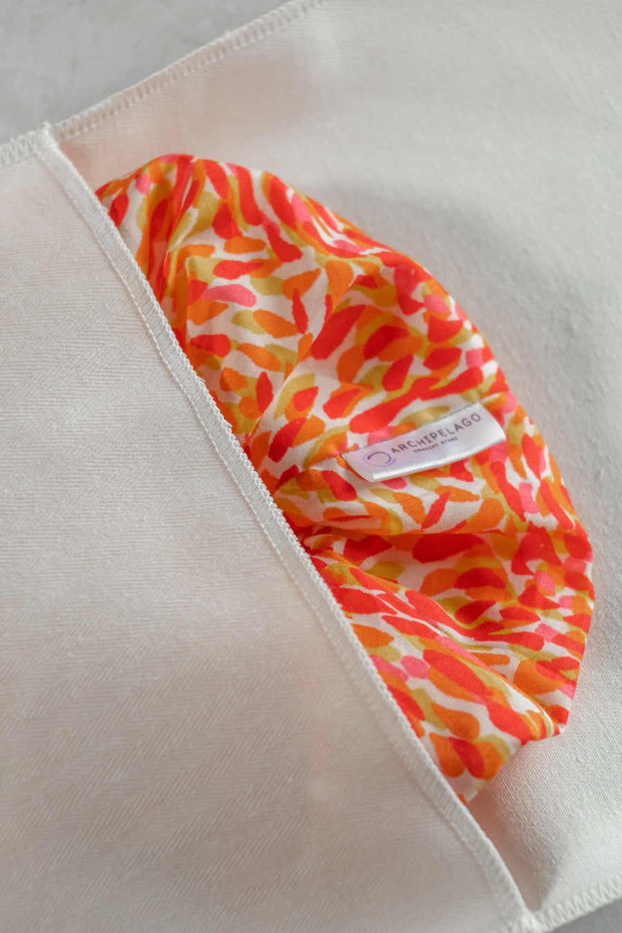 Colorful patterned Sirroco Scrunchie on a cotton pouch