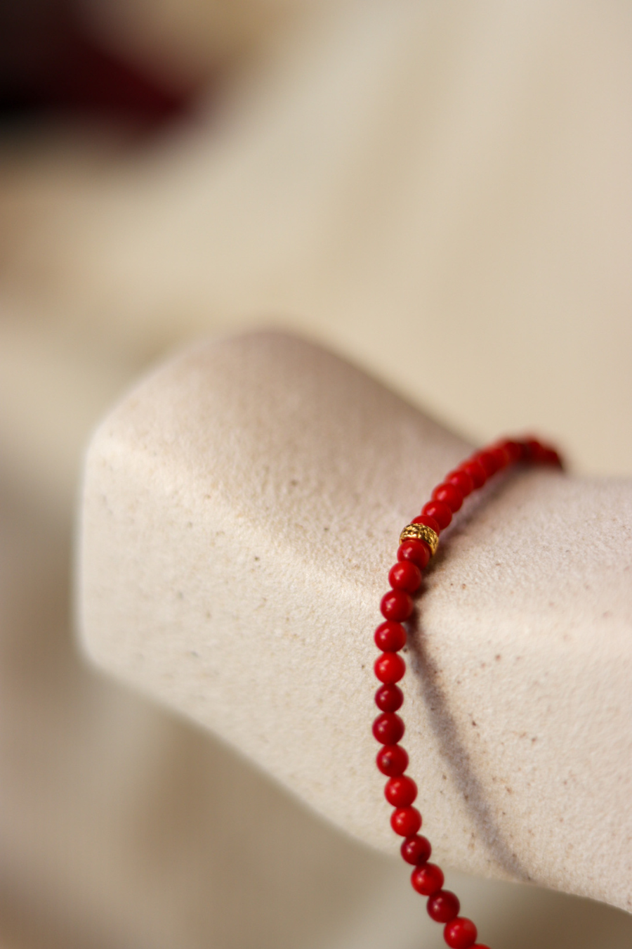 a detail from our red necklalce with a golden pomegranade charm