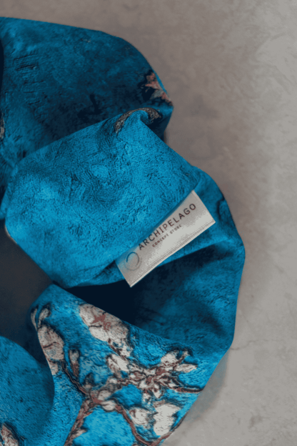 Detail of the blue textured fabric with a brand label on a gray surface