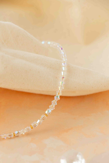 Delicate beaded bracelet on a soft beige fabric background